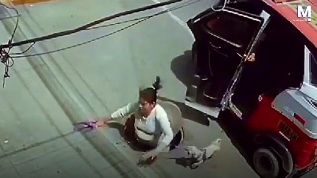 Dette er øjeblikket, hvor en kvinde falder i en kloakdæksel, efter at hun er steget ud af en auto rickshaw taxi i Lima, Peru den 17. februar. Heldigvis holdt tilskuere, der så ulykken, hendes hunds snor og sænkede en stige ned i kloakdækslet, som hun brugte til at klatre op.